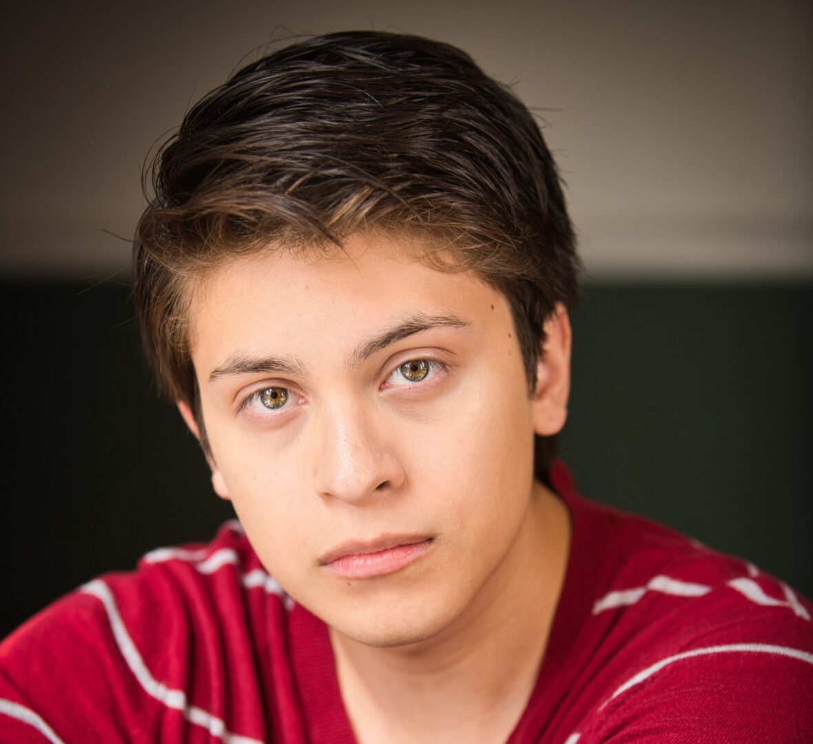 Young man with brown hair and red shirt.