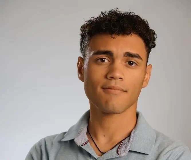 Young man with curly hair, looking at camera.