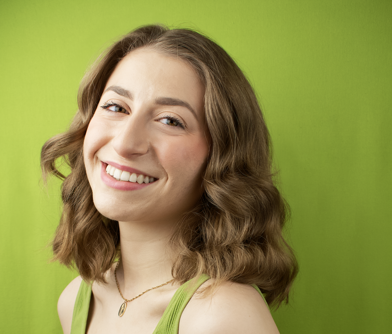 Smiling woman with brown hair and green shirt.