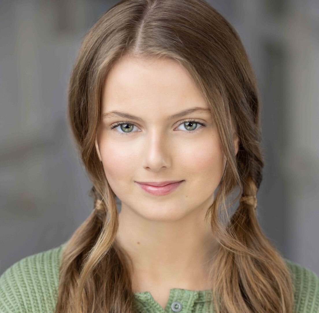 Young girl with long brown hair smiling.