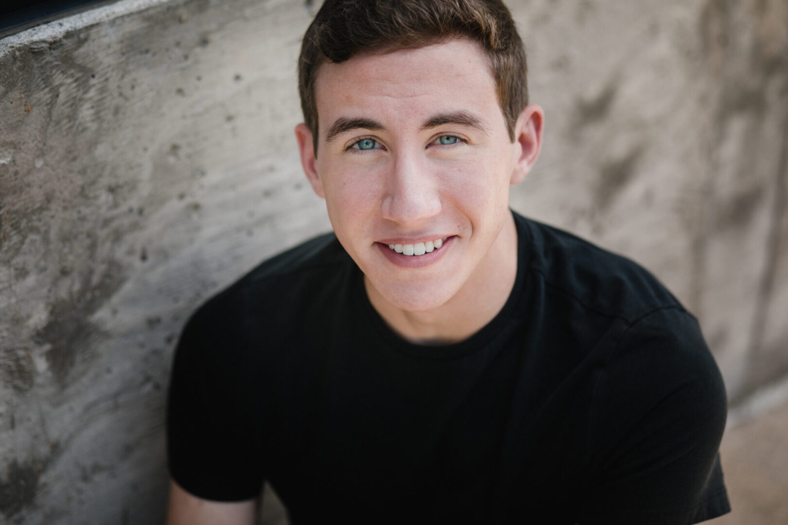 Smiling young man in a black shirt.