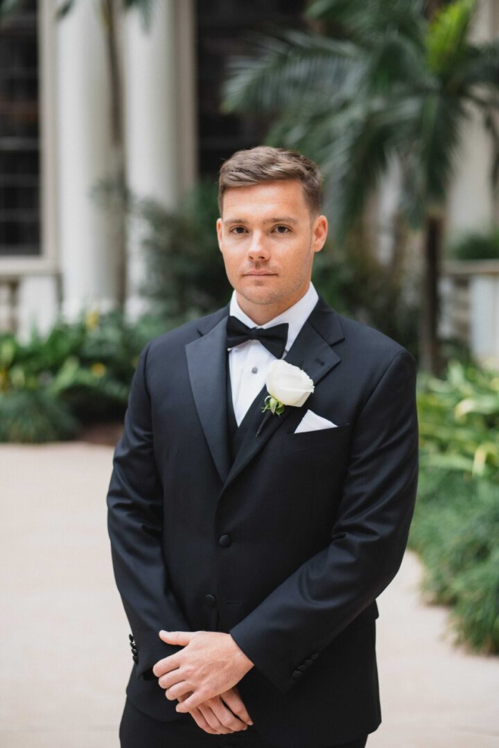 Man in tuxedo, white rose boutonniere.