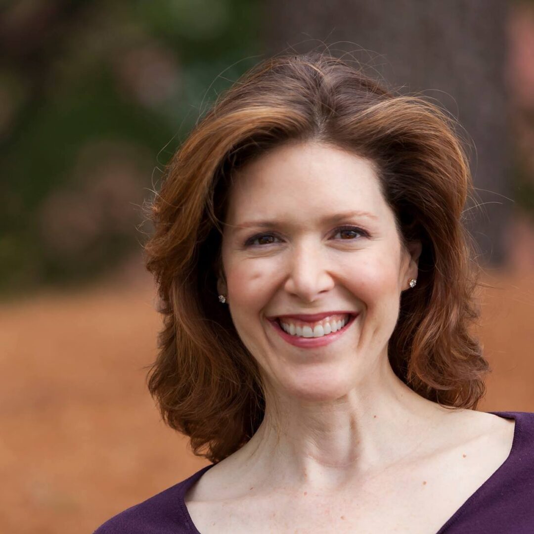 Smiling woman with auburn hair.