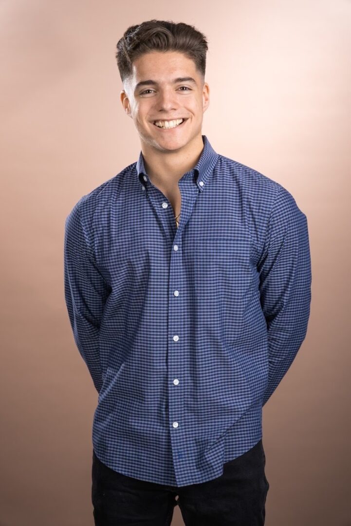 Smiling young man in blue shirt.